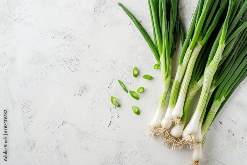 A cluster of fresh green onions arranged neatly on a clean white tabletop