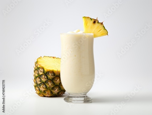 A glass of white milk with a pineapple slice on top
