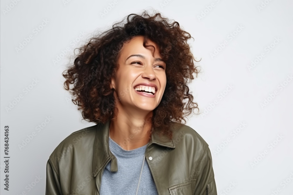 Portrait of a happy young african american woman laughing against grey background Portrait of a happy young african american woman laughing against grey background
