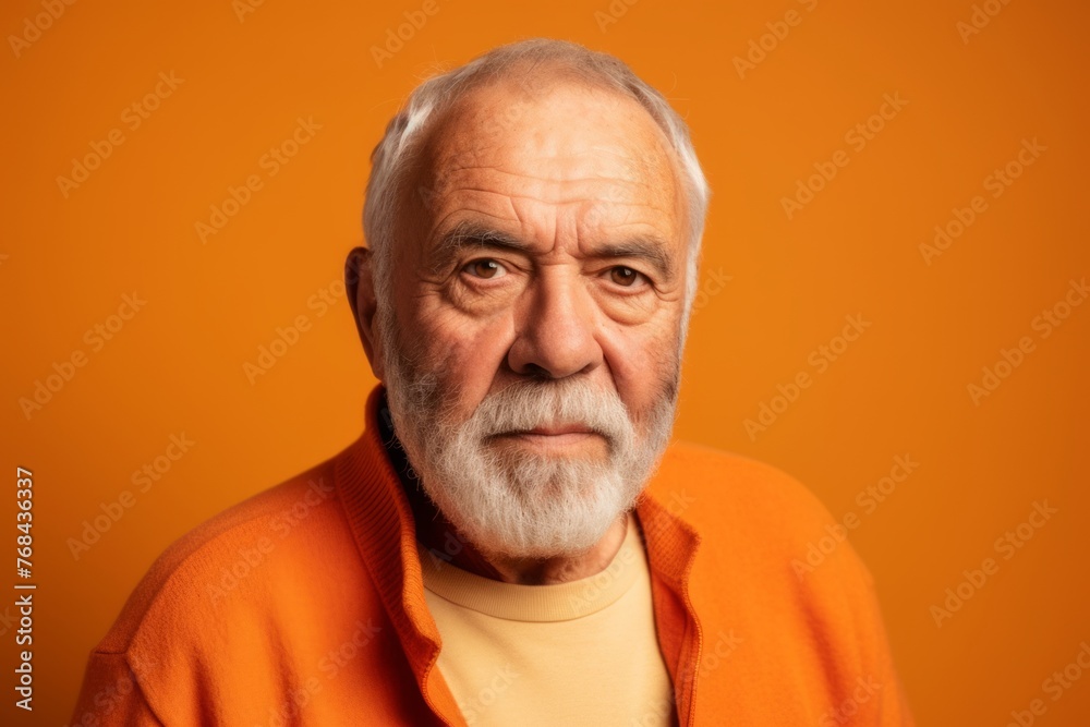 Portrait of an old man with gray beard and mustache on orange background Portrait of an old man with gray beard and mustache on orange background