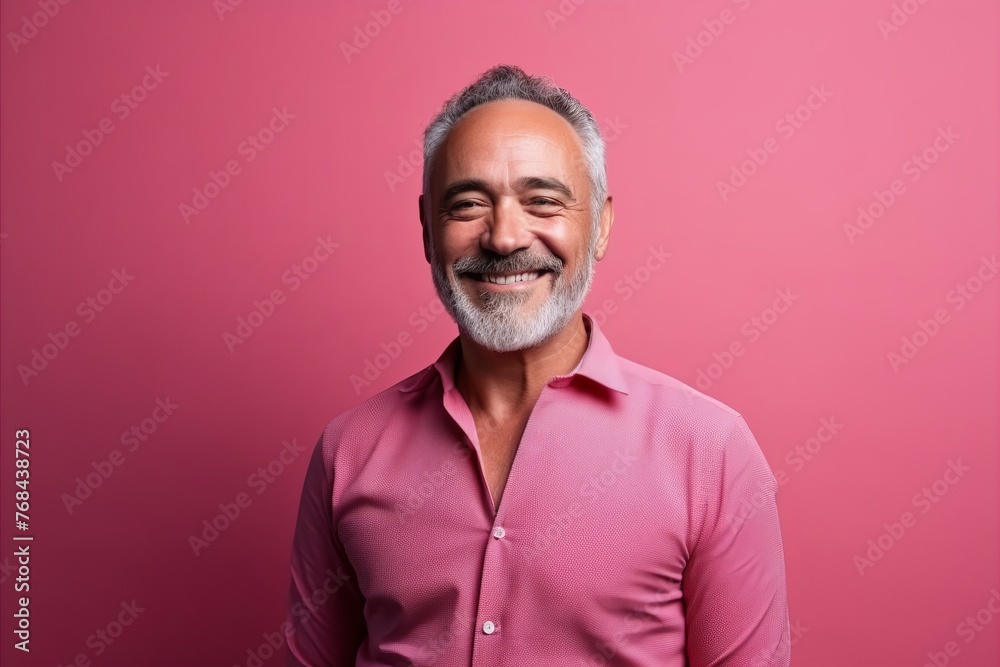 Portrait of a happy senior man smiling at the camera against a pink background Portrait of a happy senior man smiling at the camera against a pink background