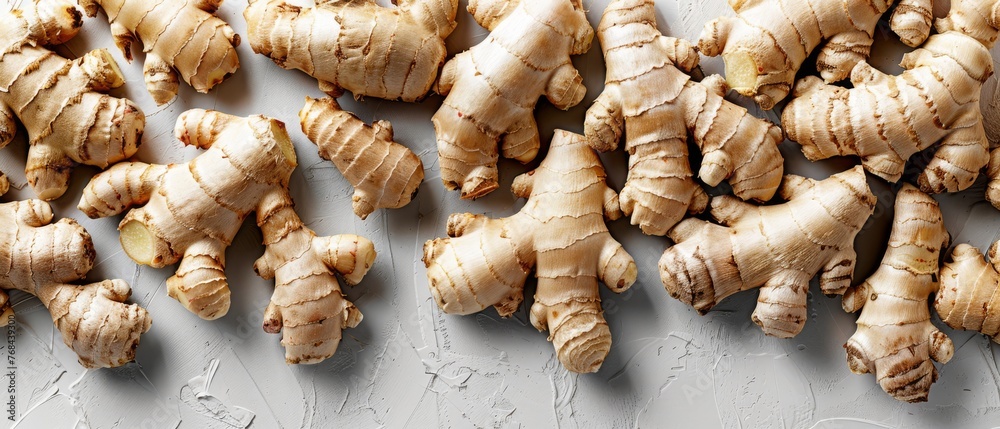   A close-up image of a group of ginger roots on a white background, featuring one root still connected to the top