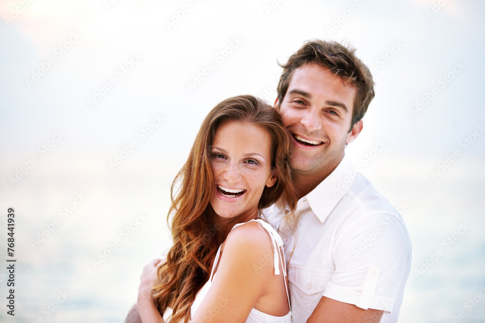 Happy couple, portrait and holiday by ocean for love and travel on honeymoon adventure in sun. Man, woman and smile face for bonding in marriage, touch and together on beach vacation in cape town