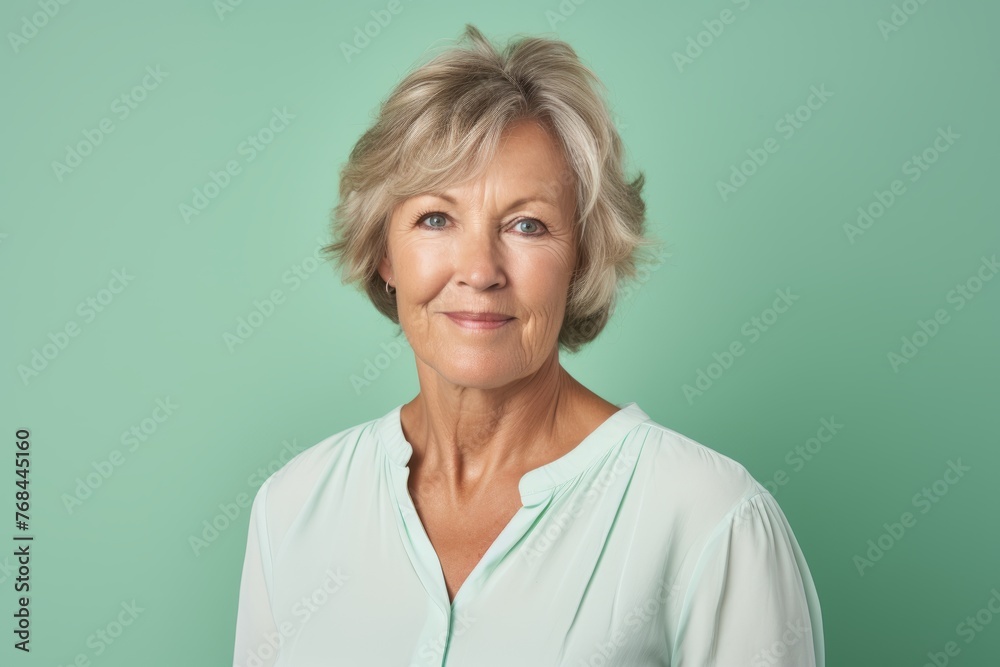 Portrait of a happy senior woman smiling at the camera against a green background Portrait of a happy senior woman smiling at the camera against a green background
