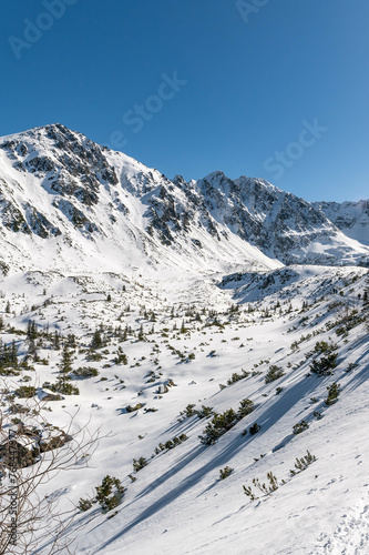 Sceneria roztaczająca się ze szlaku prowadzącego z Hali Gąsienicowej, nad Czarny Staw Gąsienicowy w Tatrach Wysokich. Zdjęcie wykonane w słoneczny, zimowy dzień. © Arsky