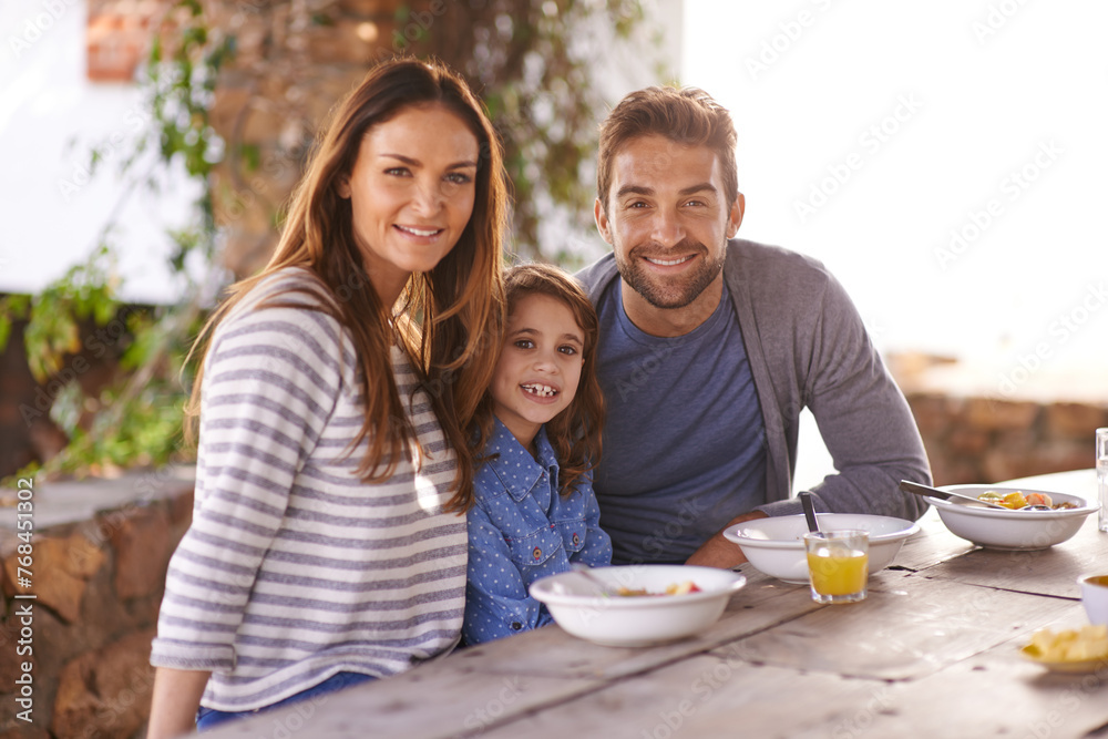Happy family, portrait and breakfast with juice, smile and garden for vacation, nutrition and bonding. Father, mother and daughter at table in morning for summer holiday, together and healthy food.