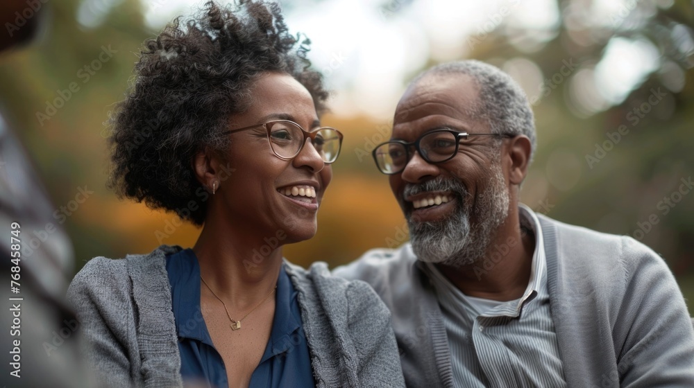 Fototapeta premium A cheerful older couple is seen in discussion with their financial advisor in a serene park setting surrounded by trees They appear to be engaged in a retirement planning meeting,with the advisor