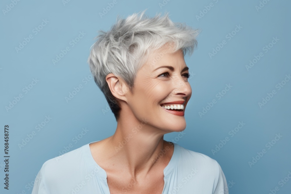 Beautiful middle aged woman with short grey hair smiling at camera.