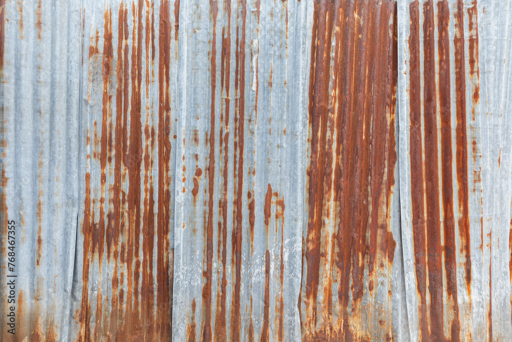 Front view of a rusty and weathered corrugated iron metal construction site wall. High resolution full frame textured grunge rust background. Front view of a rusty and weathered corrugated iron metal construction site wall. High resolution full frame textured grunge rust background.