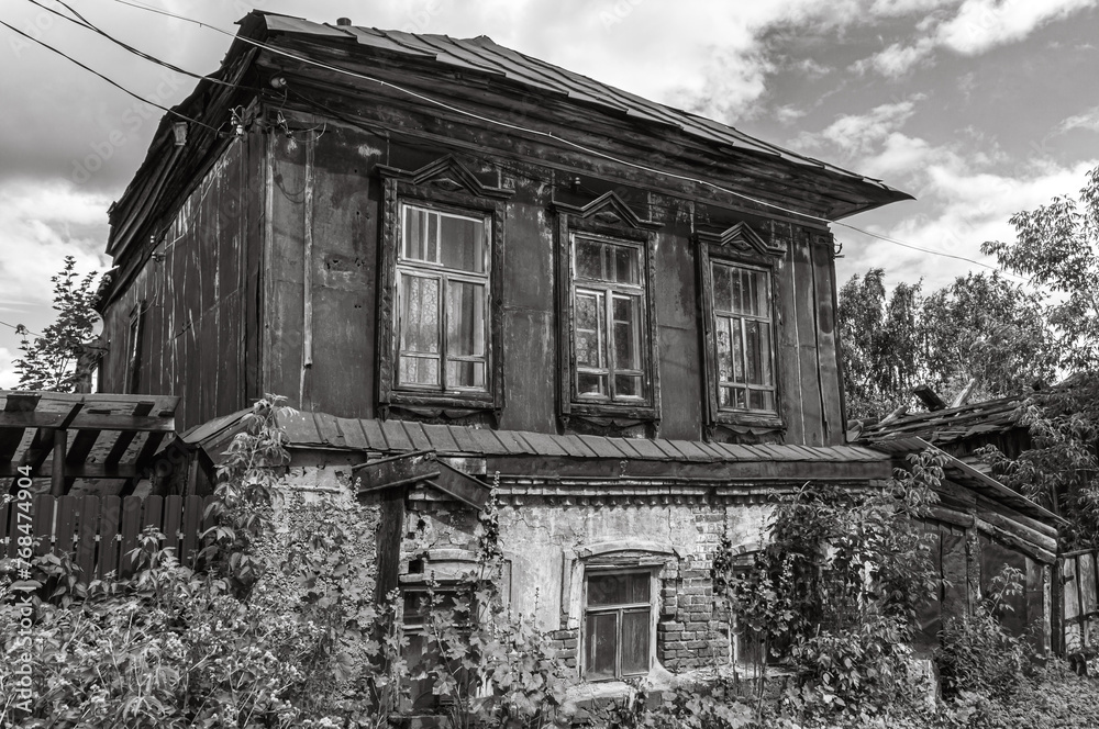 The plaster is peeling off the brick on the old house. A dilapidated house built in the 19th century. The second wooden floor of the old house is covered with iron, which is covered with rust. The plaster is peeling off the brick on the old house. A dilapidated house built in the 19th century. The second wooden floor of the old house is covered with iron, which is covered with rust.