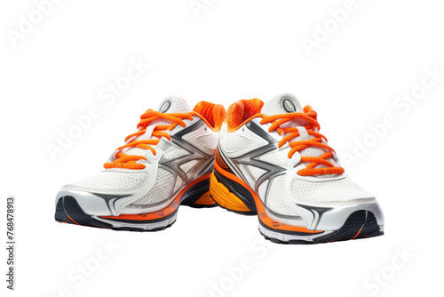 A pair of white and orange running shoes placed on a gray surface. The shoes have a breathable mesh upper and cushioned midsole. Isolated on a Transparent Background PNG.