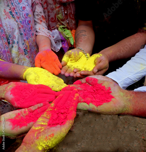 Close-up partial view of colorful powder in hands at holi festival