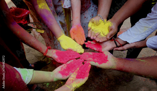 Close-up partial view of colorful powder in hands at holi festival