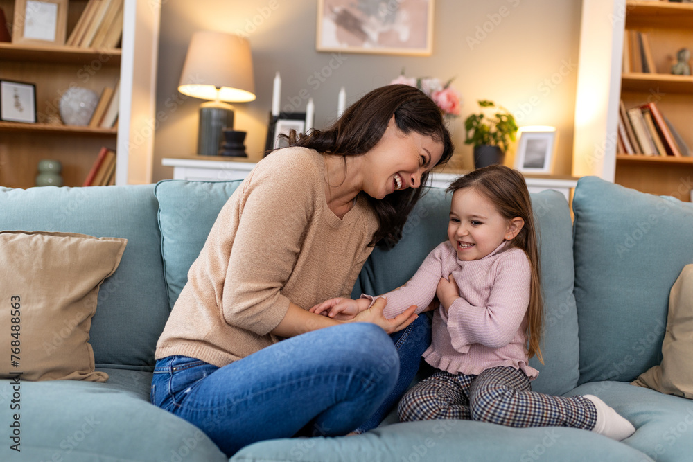 Young family, hug and portrait of child with mother, mom or mama bond, relax and enjoy quality time together. Love, happy family and woman with kid girl smile, care or lounge on home living room sofa