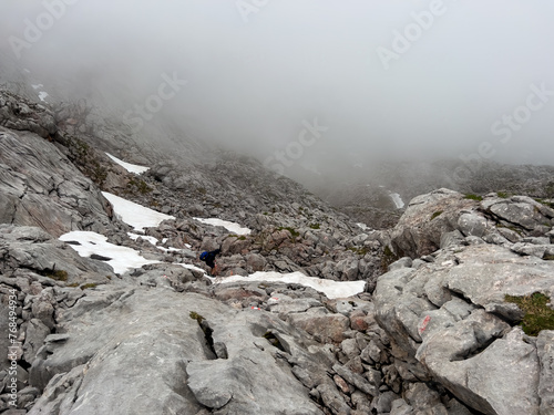 A hike though the Berchtesgaden landscape during summer with rain clouds and remaining snow fields