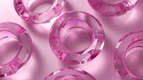 Multiple pink glass circular rings on a reflective surface creating a modern abstract background.