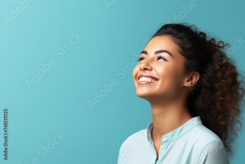 Portrait of happy smiling young beautiful Asian woman, over blue background