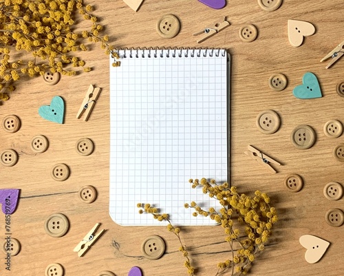 Notepad on a wood background with plant and wood beads border