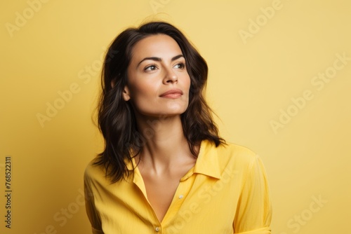 Portrait of a beautiful young woman in yellow shirt on yellow background © Chacmool