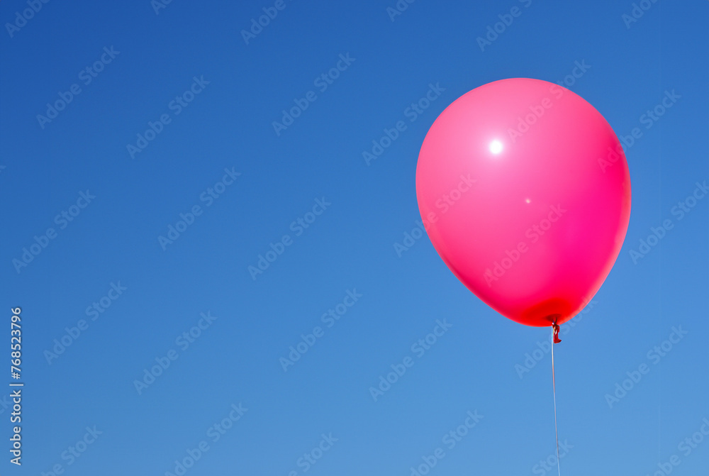 青空を背景に浮かぶピンクの風船