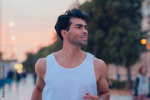Man running through the streets of a city at sunset in sportswear
