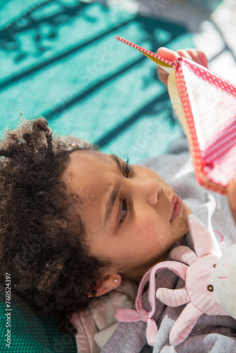 Literary Escape: Cute mixed race little Girl Lost in a Book photo