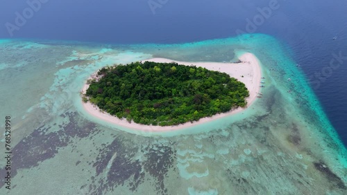 Aerial shot of the small Mantigue Island, covered with trees, in the Philippines. photo