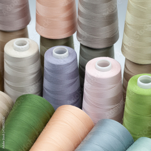 Thread spools background. Various colors sewing kit. Collection of threads. Pale pastel colors. Sew threads. Colorful hobby background. Tailor shop texture. Isolated on white.