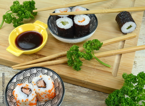 Sushi Set nigiri and sushi rolls on wooden serving board with soy sauce and chopsticks