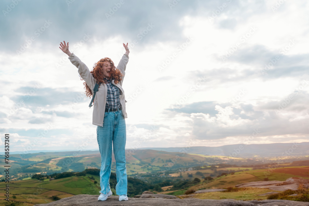 amazing redhead woman with backpack raising her hands, reaching the destination and enjoying mountains landscape on the top of mountainon cloudy day. Enjoy hiking and exploring new places concept amazing redhead woman with backpack raising her hands, reaching the destination and enjoying mountains landscape on the top of mountainon cloudy day. Enjoy hiking and exploring new places concept