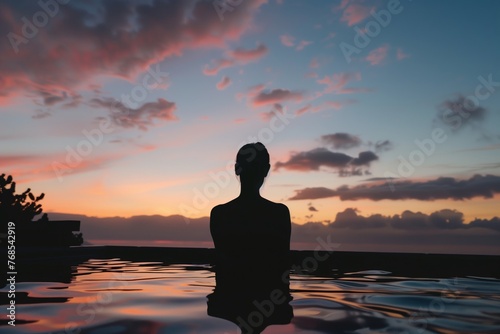silhouette of a person enjoying an onsen with sunset colors in the sky