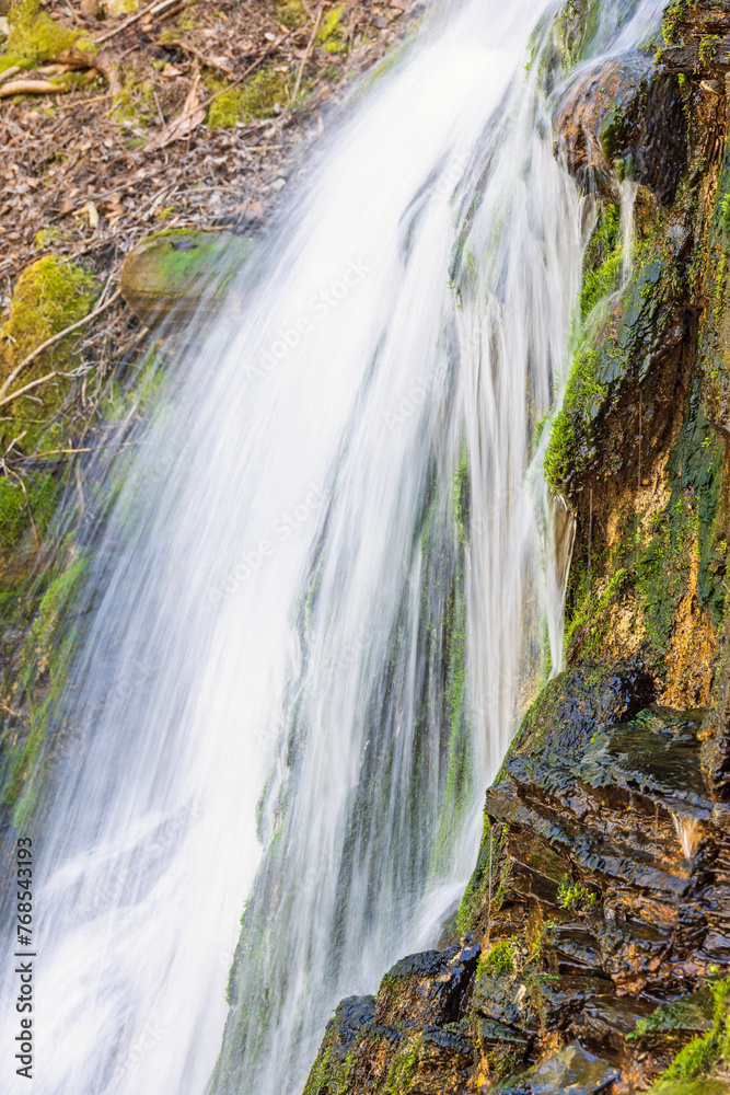 Obraz premium Falling water in a waterfall on a cliff