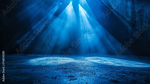 Blue spotlights illuminate an empty stage. The stage is covered in a thin layer of water, which reflects the light and creates a shimmering effect. photo