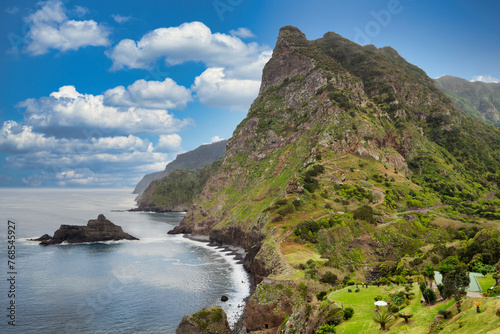 Fototapeta Naklejka Na Ścianę i Meble -  The view of the Madeira coastline, where the vast ocean meets towering cliffs under a sky adorned with wispy clouds. Nature in Madeira delights with its harmonious blend of land, water, and sky.