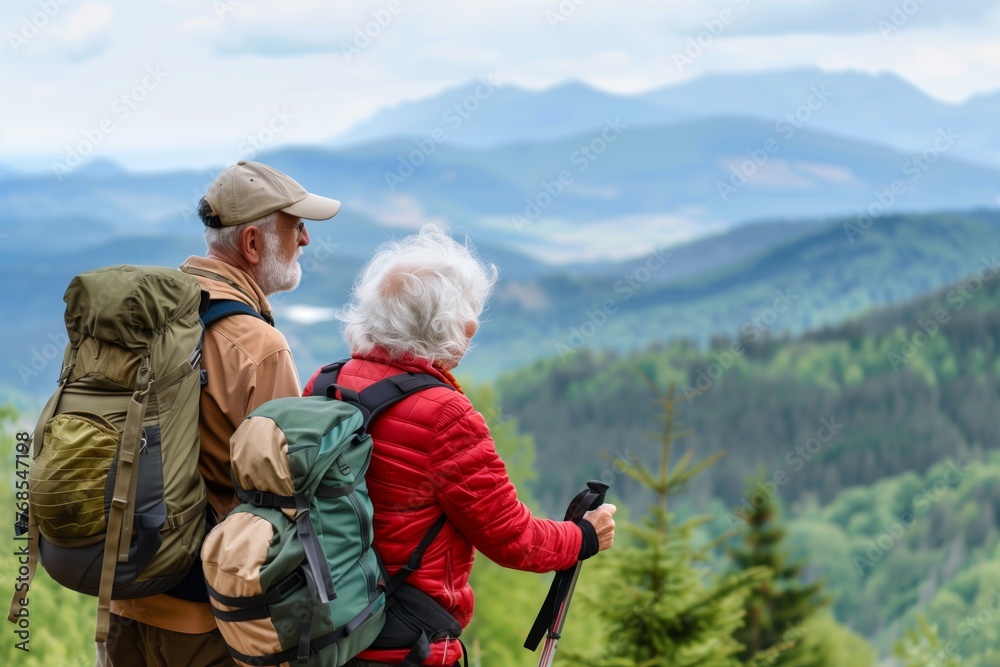 older couple with hiking gear overlooking a mountain view
