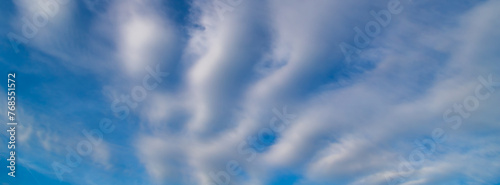 Beautiful blue sky with white Altocumulus undulatus clouds.