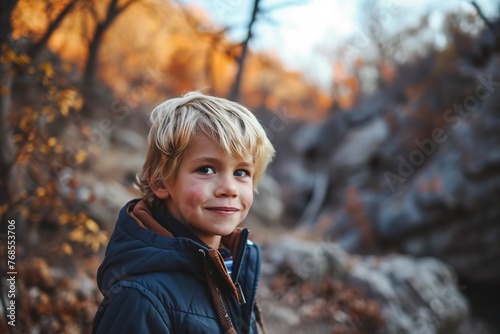 Portrait of a smiling boy in the autumn forest. The boy is standing in the autumn forest.