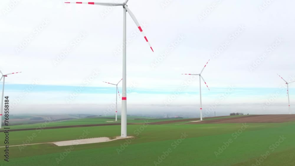 Wind Power Turbine Spinning Towering On Greenery Plains. Aerial Ascending Shot Wind Power Turbine Spinning Towering On Greenery Plains. Aerial Ascending Shot