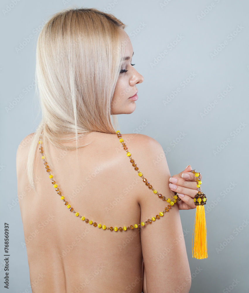 Jewelry fashion female model with long blonde hairstyle and shiny fresh skin on white background, studio portrait