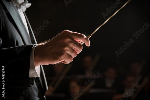 closeup of conductors hand holding a baton