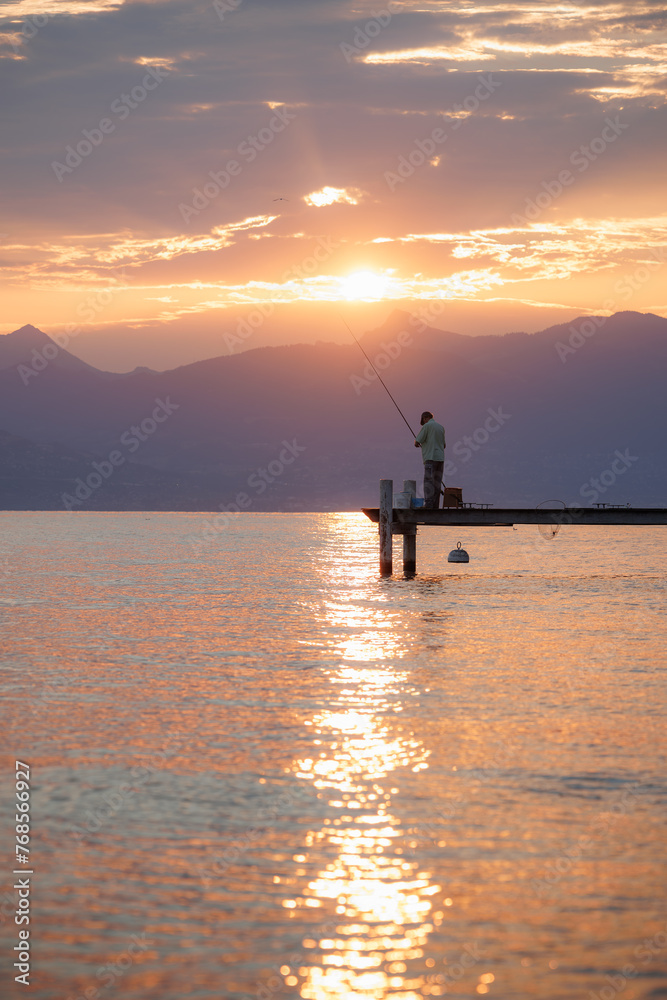 Pécheur isolé sur un ponton sur les bords du Lac Léman, au lever du soleil, Evian-les-Bains, Haute Savoie
