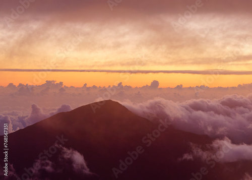 View of the gorgeous sunrise through the clouds over Haleakala volcano summit at Haleakala National Park on the island of Maui, Hawaii, USA