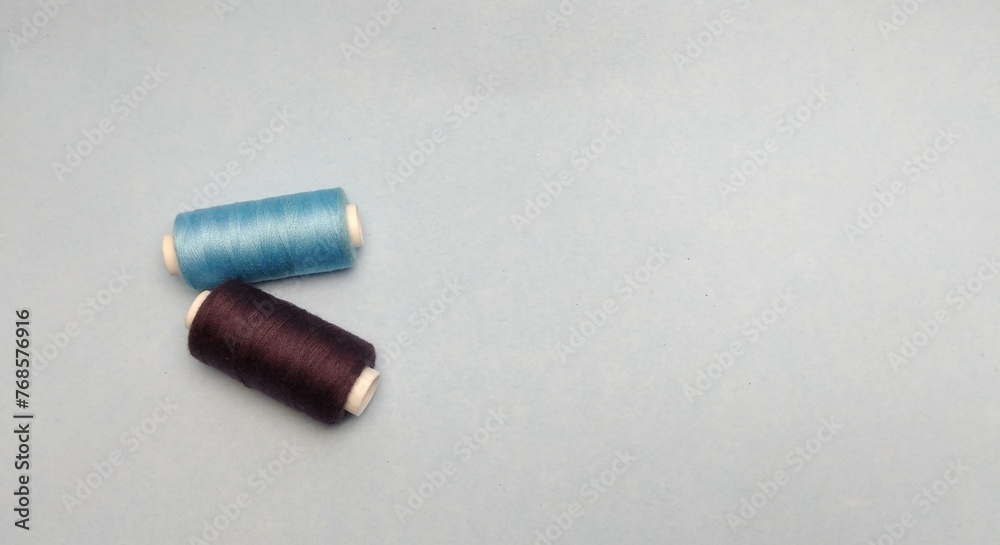 spools of thread on a blue background. place for text. spools of thread on a blue background. place for text.