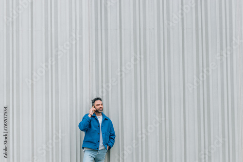 young man with blue jacket and mobile phone outdoors © carballo