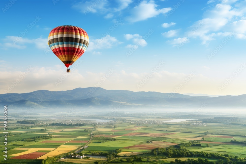 Obraz premium Aerial view of hot air balloon flying above verdant fields with ample copy space