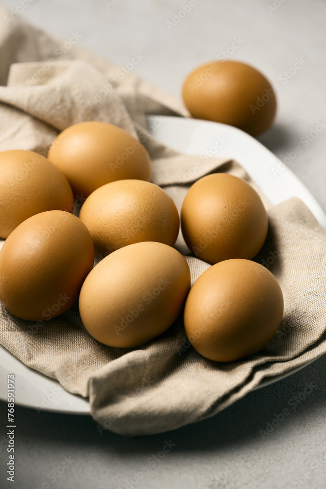 Raw eggs on a plate with drapery Raw eggs on a plate with drapery
