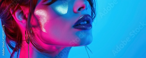 High fashion stunning beautiful woman portrait with metallic silver lips and face, colorful bright neon lights, professional studio photo