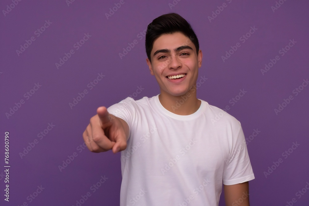 mexican american male person with toothy smile on face pointing with index finger on empty space over violet background. Handsome young guy indicating place for advertising text in studio mexican american male person with toothy smile on face pointing with index finger on empty space over violet background. Handsome young guy indicating place for advertising text in studio