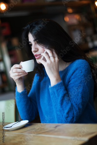 Woman chatting on phone in cafe