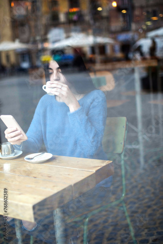 Woman texting at a cafe